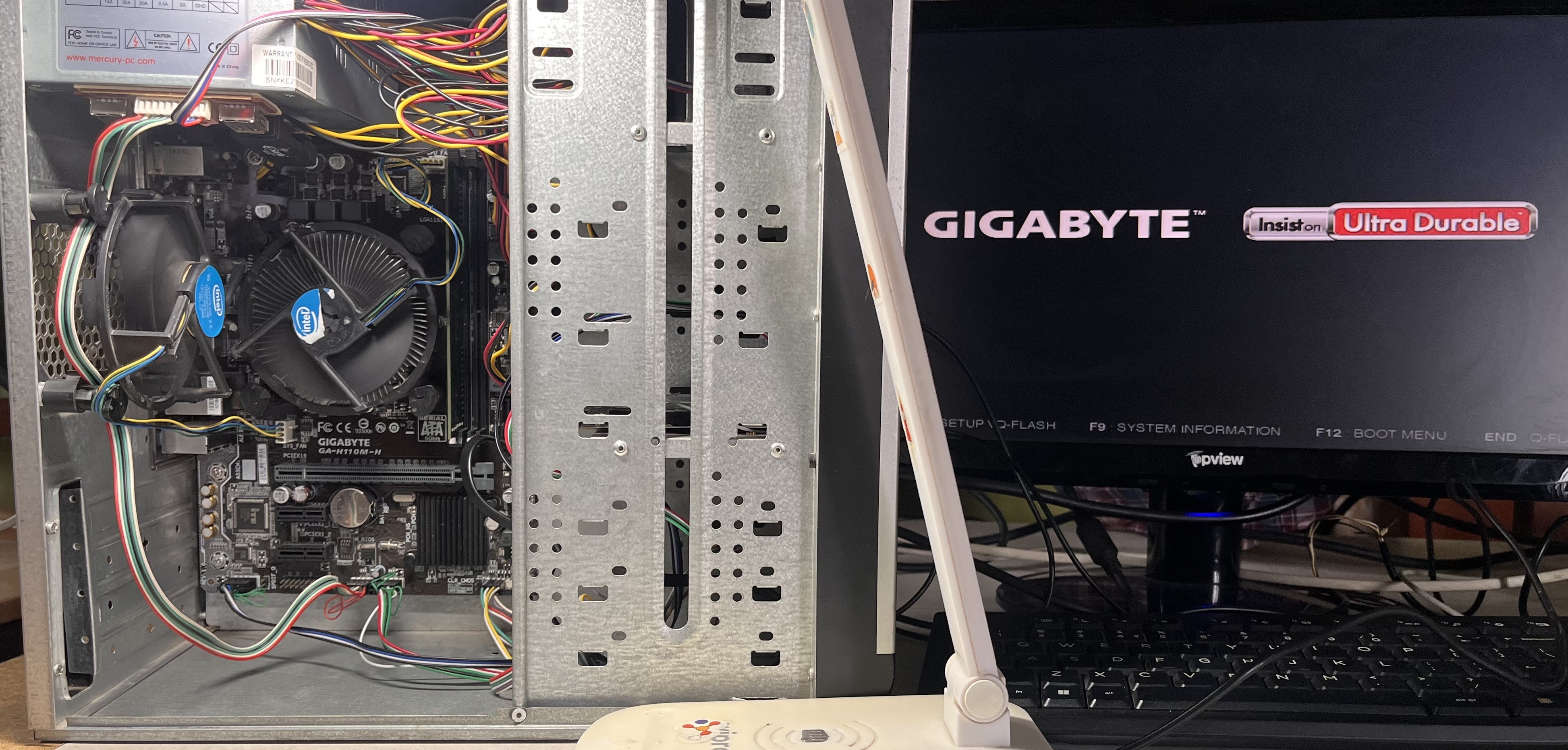 The parts fitted into the salvaged case, with the Gigabyte splash screen on the monitor