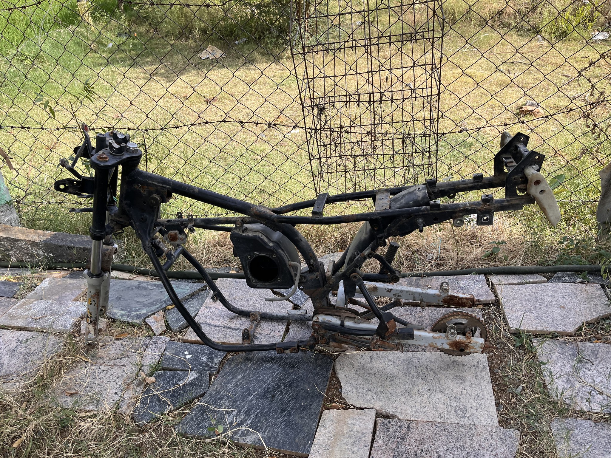 Stripped bare frame outdoors, engine removed
