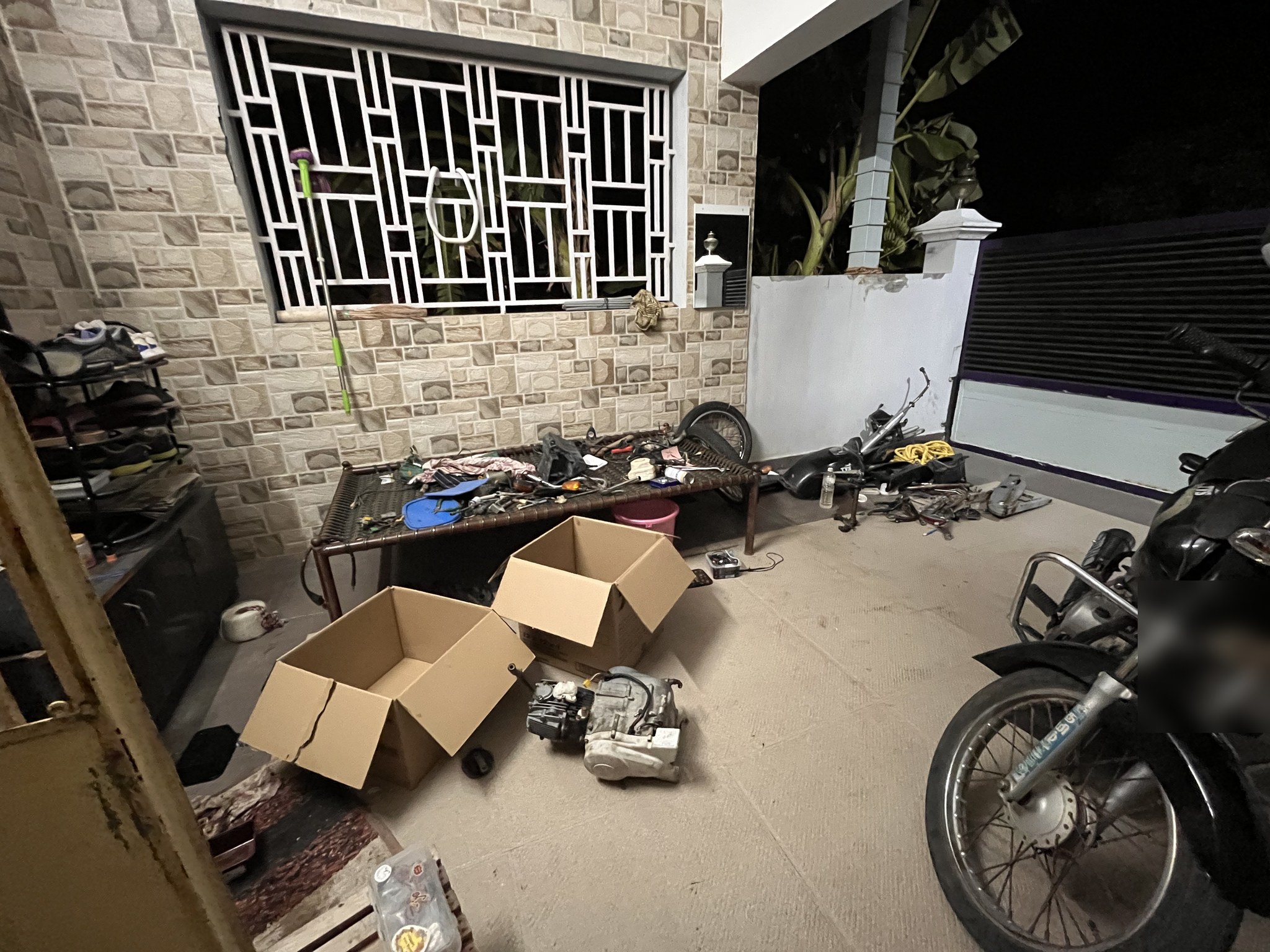Night teardown with parts and engine on porch