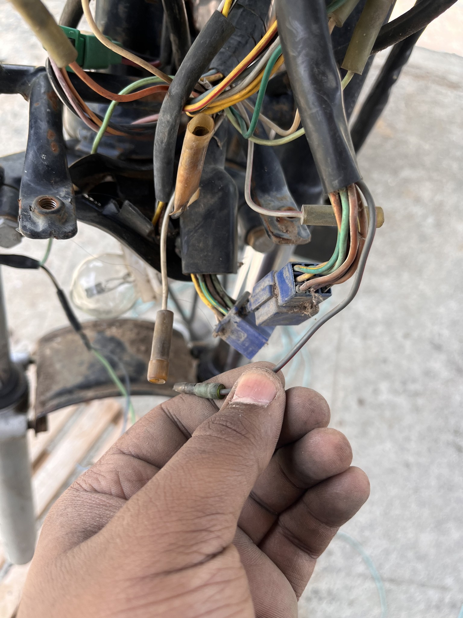Hand holding a wire bullet connector during rewiring
