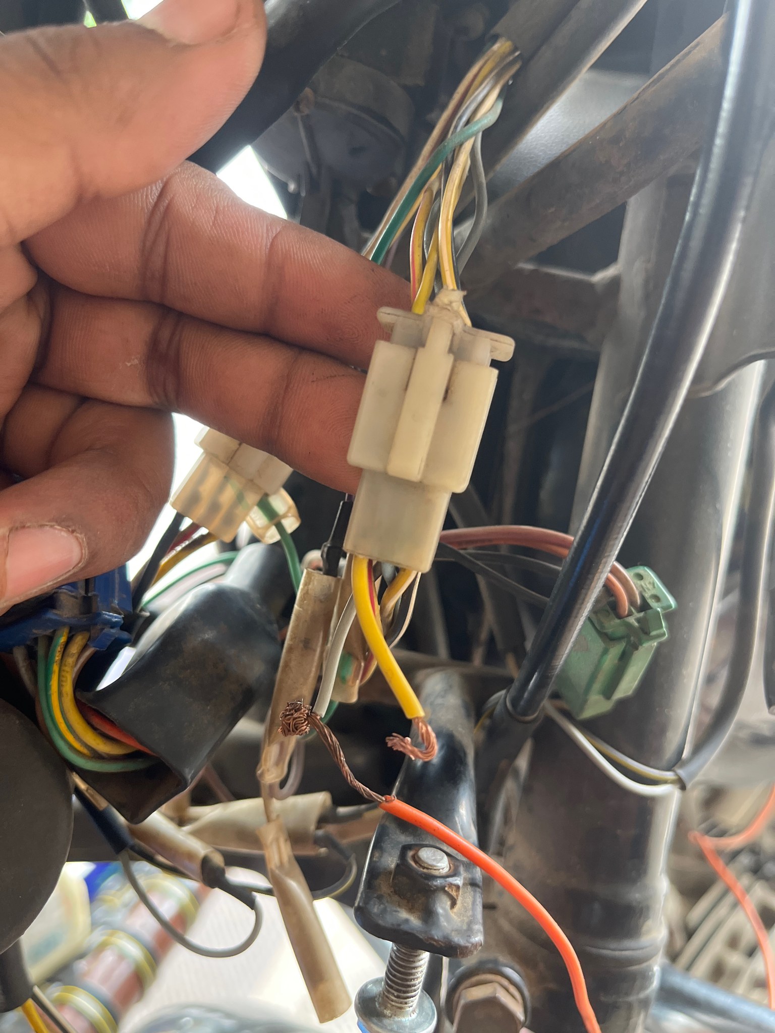 Hand holding harness connector with spliced wires
